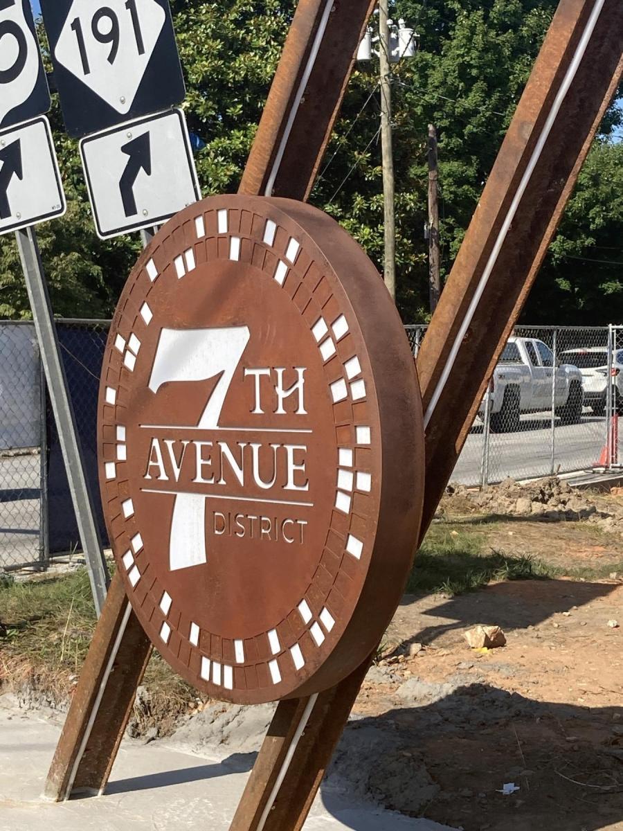 new 7th avenue sign with iron structure looking like railroad tracks