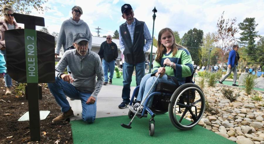 girl in wheelchair and man at a mini golf course