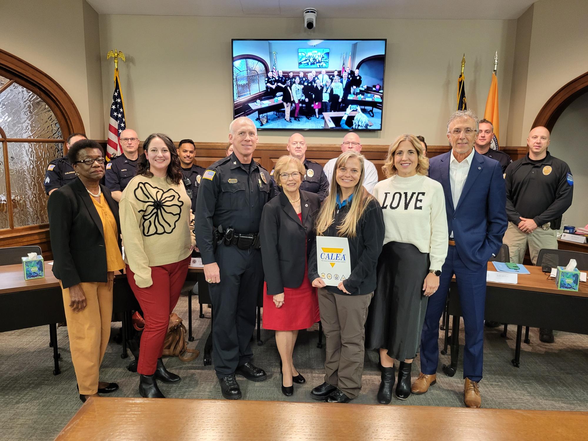 City Council Members, Police Chief, Officers and Support Staff holding a certificate that says CALEA